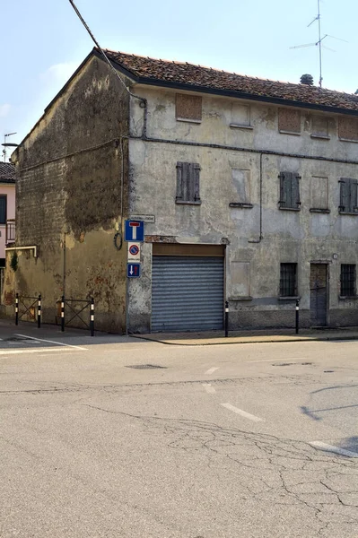 stock image Crossroads between an alley and a road with a closed shop in the corner on a sunny day