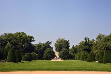 Güneşli bir günde parktaki patikaların arasında çitlerle çevrili