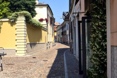 Güneşli bir günde İtalyan kasabasında kaldırımlı ve boş bir cadde