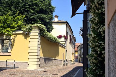 Güneşli bir günde İtalyan kasabasında kaldırımlı ve boş bir cadde