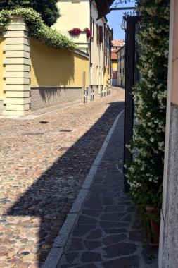 Güneşli bir günde İtalyan kasabasında kaldırımlı ve boş bir cadde