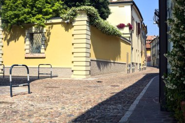 Güneşli bir günde İtalyan kasabasında kaldırımlı ve boş bir cadde
