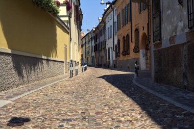 Güneşli bir günde İtalyan kasabasında kaldırımlı ve boş bir cadde