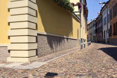 Güneşli bir günde İtalyan kasabasında kaldırımlı ve boş bir cadde