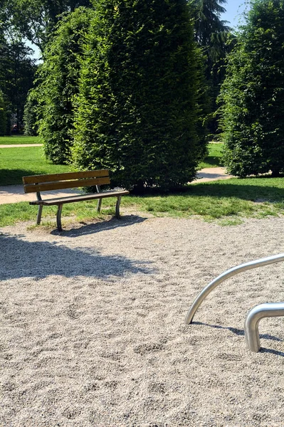 晴れた日に公園の遊び場の端に空のベンチ — ストック写真