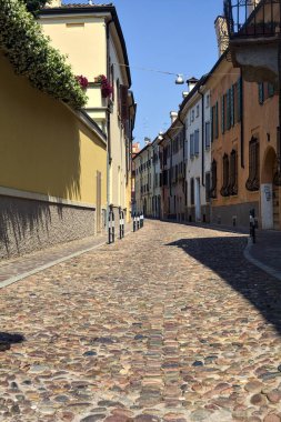 Güneşli bir günde İtalyan kasabasında kaldırımlı ve boş bir cadde