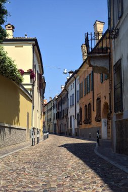 Güneşli bir günde İtalyan kasabasında kaldırımlı ve boş bir cadde