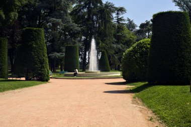 İtalya 'da güneşli bir günde çeşmeye giden bir parkın yolu.