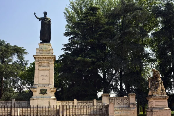 Güneşli bir günde parkta Publio Virgilio Marone anısına dikilmiş bir anıt.