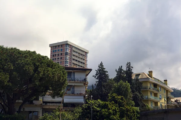 stock image Skyscrapers in a city with a mountain ridge and buildings in the background on a cloudy day in summer