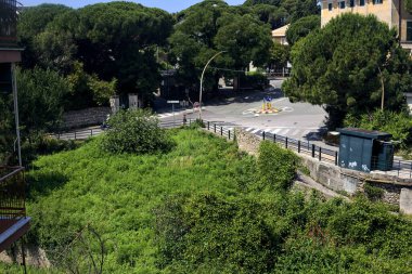 Bir parkın yanında döner kavşak ve güneşli bir yaz gününde bir italyan şehrinde yukarıdan görülen yükseltilmiş bir yol.