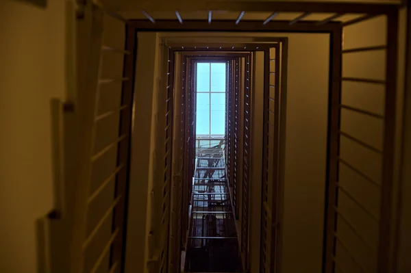 下から見える天井の窓のある住宅ビルの階段とエレベーター — ストック写真
