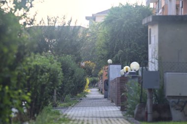 Fabrikalarla çevrili bir pansiyon ve gün batımında bir İtalyan kasabasında bir apartman dairesi duvarı.