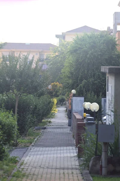 日落时分 意大利一个小镇上的街道被植物和公寓楼的围墙围绕着 — 图库照片