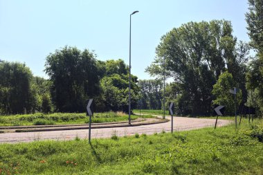 Yazın İtalya kırsalında ağaçlarla çevrili bir köy yolunda viraj