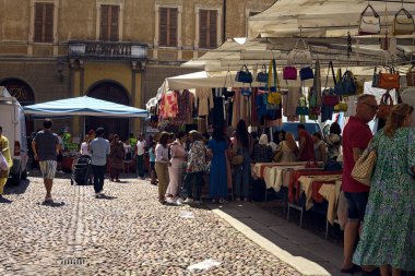 İtalya 'da güneşli bir günde insanların bakındığı tezgahlar.