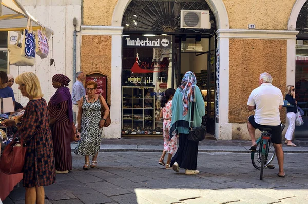 İtalya 'da güneşli bir günde insanların bakındığı tezgahlar.