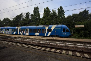 Tren bulutlu bir günde İtalya kırsalındaki bir istasyona varıyor.