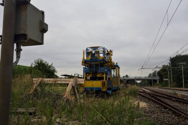 İtalya 'nın kırsal kesimlerinde bulutlu bir günde rayların kenarından görülen tren yolu ve servis aracı.