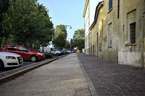 日落时分 在意大利一个小镇靠近一座建筑物的人行道和停放的汽车旁边 — 图库照片