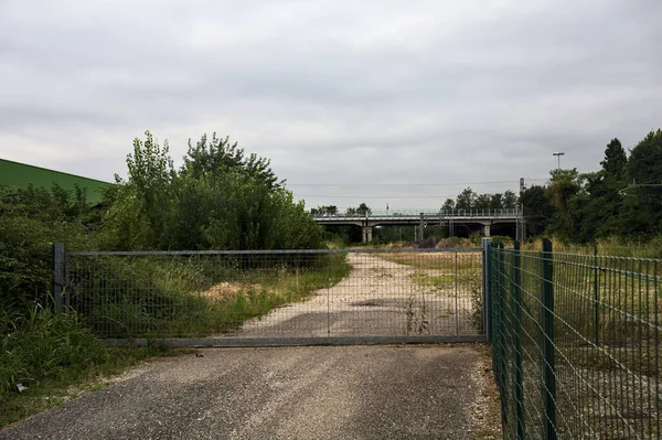 Worn Gravel Road Closed Gate Bordered Bushes Leads Railroad Tracks — Stock Photo, Image