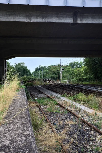 stock image Railroad tracks in the shade under a viaduct on a cloudy day in the italian countryside