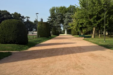 Gün batımında bir parkta bir çeşmeye giden yol.