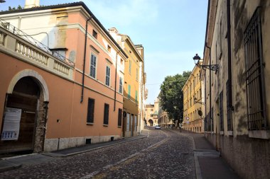 Günbatımında bir İtalyan kasabasında tarihi binalarla çevrili bir cadde.