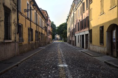 Günbatımında bir İtalyan kasabasında tarihi binalarla çevrili bir cadde.