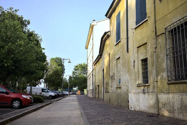 日落时分 在意大利一个小镇靠近一座建筑物的人行道和停放的汽车旁边 — 图库照片