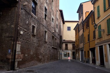 Bir sarayın arkasındaki kaldırımlı sokakta gün batımında İtalyan kasabasında bir tabela vardı.