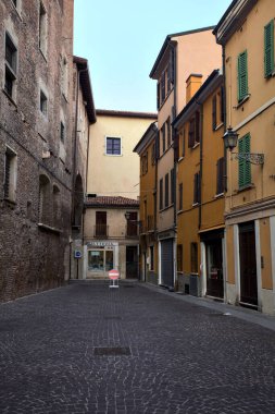Bir sarayın arkasındaki kaldırımlı sokakta gün batımında İtalyan kasabasında bir tabela vardı.