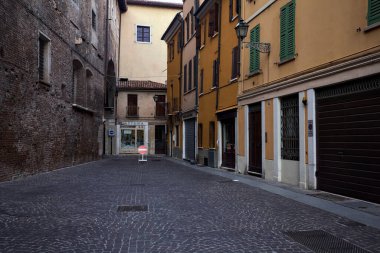 Bir sarayın arkasındaki kaldırımlı sokakta gün batımında İtalyan kasabasında bir tabela vardı.