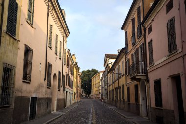 Günbatımında bir İtalyan kasabasında tarihi binalarla çevrili bir cadde.
