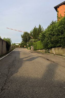 Evlerle ve setle çevrili bir tepede yol.