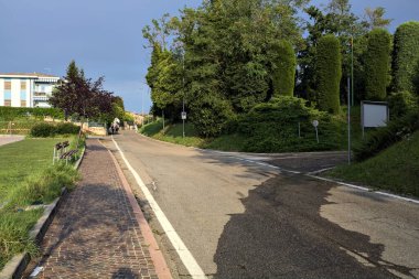 Bulutlu bir günde, binaların yanındaki tepede ve otoparkta.