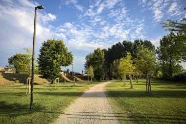 İtalya 'da gün batımında setin yanındaki ağaçların olduğu bir parkta yol.