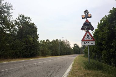 Yağmur yağmadan önce bulutlu bir günde ağaçlarla çevrili bir köy yolu.