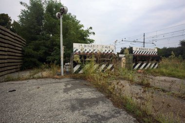 İtalya kırsalında bulutlu bir günde tren istasyonunun açıklığında üç çıkmaz yol.