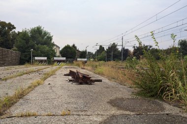 İtalya kırsalında bulutlu bir günde tren istasyonunun açıklığında üç çıkmaz yol.