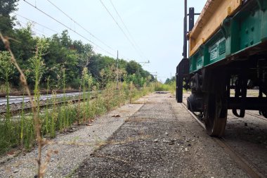 Tren raylarının kenarındaki vagon bulutlu bir günde tren istasyonunun açıklığından görülüyor.