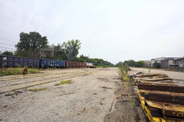 İtalya 'nın kırsal kesimlerinde bulutlu bir günde tren vagonlarıyla ormanın yanındaki bir demiryolunda.