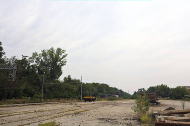 İtalya 'nın kırsal kesimlerinde bulutlu bir günde tren vagonlarıyla ormanın yanındaki bir demiryolunda.
