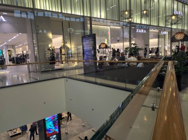 Dükkanları ve koridorları olan ve Adigeo alışveriş merkezinde gezinen insanlar.