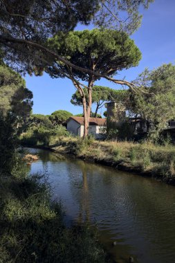 Gün batımında İtalyan sahilinin yanındaki bir kasabanın yanındaki parkta su akıntısı.
