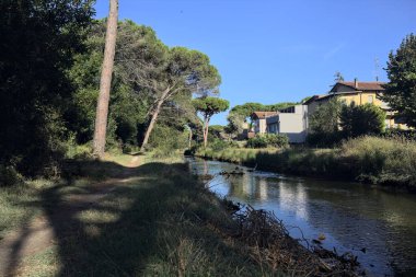 Gün batımında İtalyan sahilinin yanındaki bir kasabanın yanındaki parkta su akıntısı.