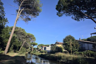 Gün batımında İtalyan sahilinin yanındaki bir kasabanın yanındaki parkta su akıntısı.