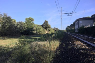 Gün batımında şehrin yanındaki ormandan geçen kablolu tren yolu.