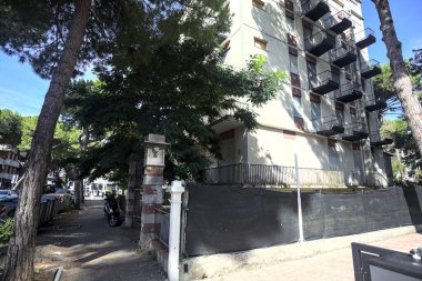 Terk edilmiş otel güneşli bir günde İtalya 'nın göbeğinde deniz çam ağaçlarıyla çevrili.