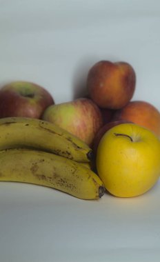 Beyaz arka planda meyveler yakından görülüyor